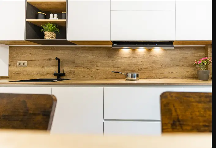 Cucina bianca con schienale in legno e piano a induzione