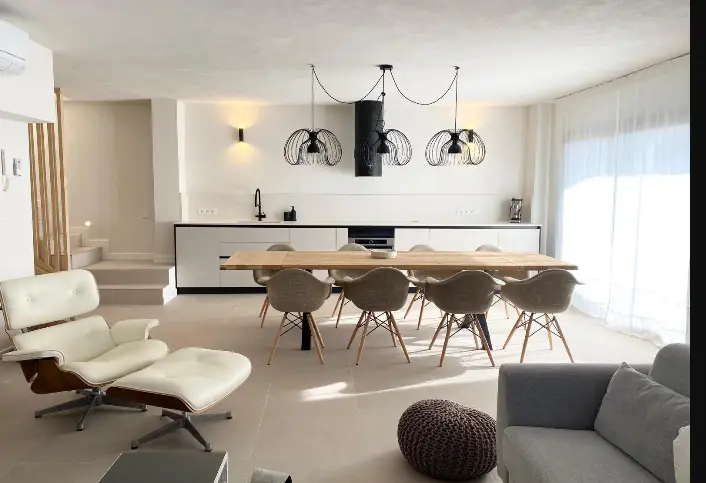 Ambiente aperto con cucina, tavolo da pranzo e zona soggiorno