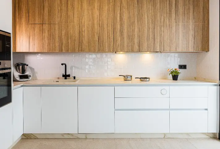 Cucina bianca con pensili in legno e piano a induzione invisibile